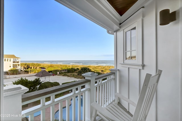 balcony featuring a water view and a view of the beach