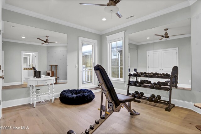 exercise room featuring baseboards, crown molding, visible vents, and wood finished floors