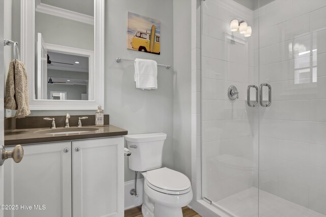 bathroom featuring ornamental molding, a stall shower, vanity, and toilet