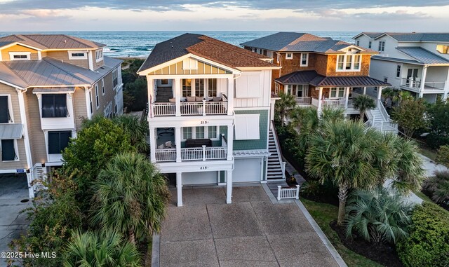 coastal inspired home featuring driveway, stairs, a residential view, and board and batten siding