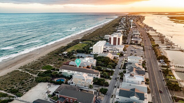 birds eye view of property with a water view and a beach view