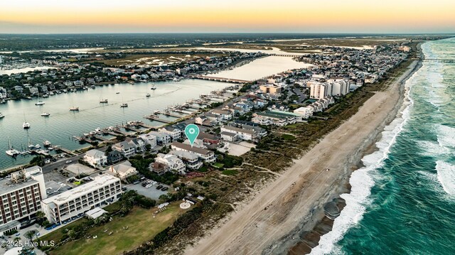 birds eye view of property with a water view and a beach view