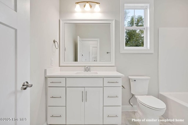 full bath with marble finish floor, toilet, a bathing tub, vanity, and baseboards