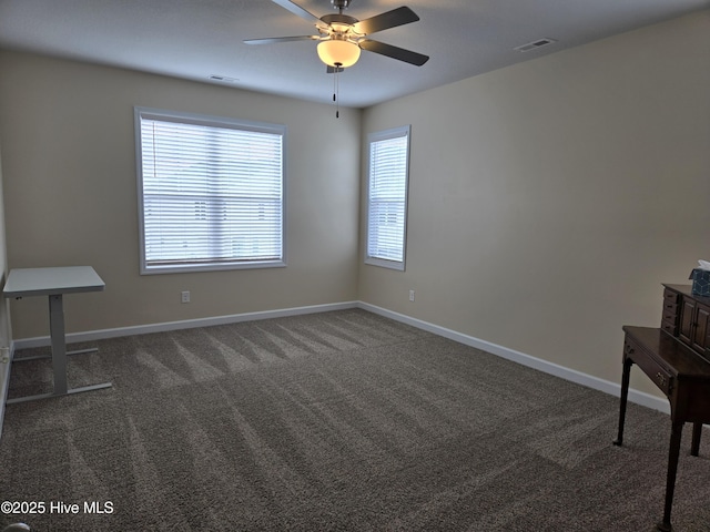 interior space with baseboards, visible vents, and a ceiling fan