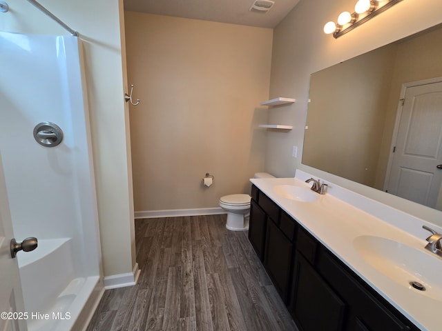 bathroom featuring a shower, wood finished floors, and a sink