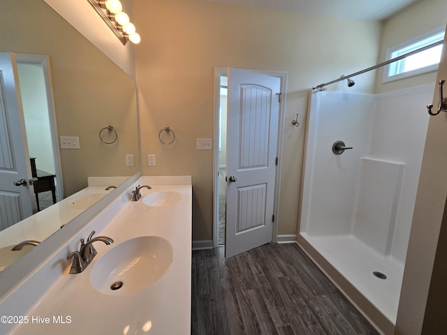 full bath featuring a shower, wood finished floors, and a sink