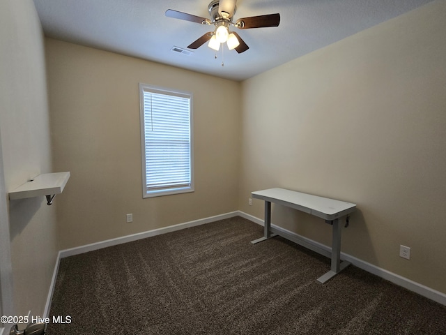 unfurnished room featuring ceiling fan, dark carpet, visible vents, and baseboards