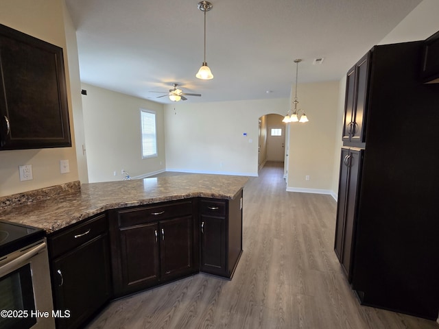 kitchen featuring arched walkways, light wood-style flooring, ceiling fan, a peninsula, and stainless steel electric range