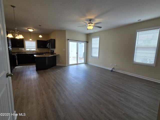 kitchen with visible vents, dark wood-type flooring, open floor plan, dark cabinets, and baseboards