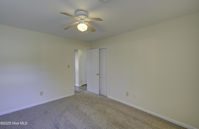 unfurnished bedroom featuring ceiling fan, a closet, baseboards, and carpet flooring