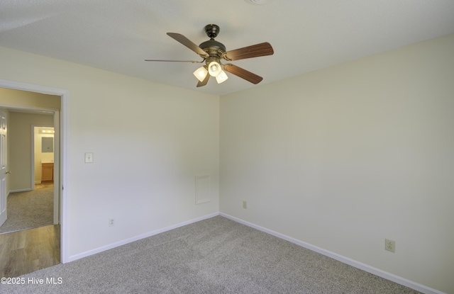 empty room with ceiling fan, baseboards, and light colored carpet