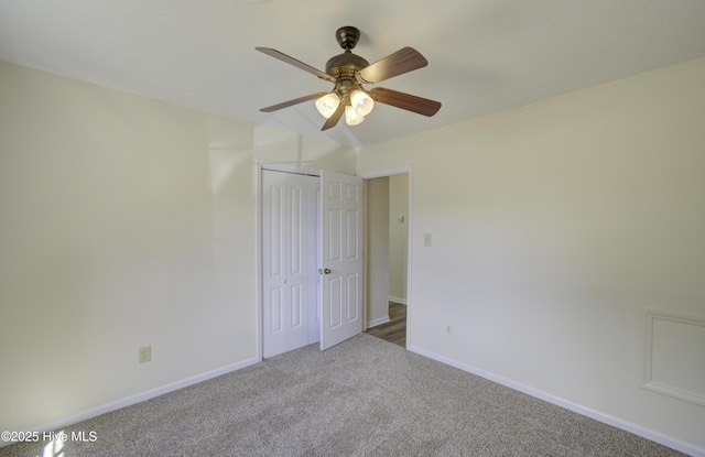 unfurnished bedroom with a closet, carpet, a ceiling fan, and baseboards