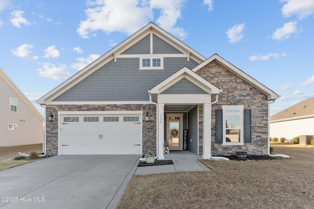 view of front facade featuring stone siding, a front yard, concrete driveway, and an attached garage