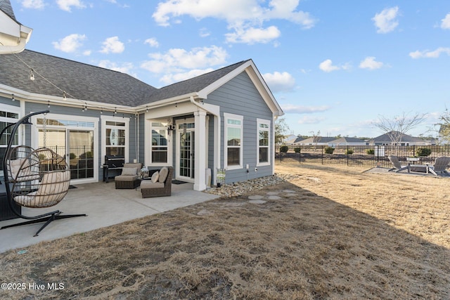 back of house featuring a patio area, a shingled roof, and fence