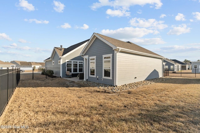 back of house with a patio, a fenced backyard, and a lawn