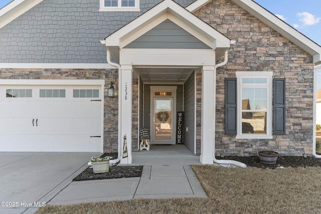 view of exterior entry featuring a garage, stone siding, and concrete driveway