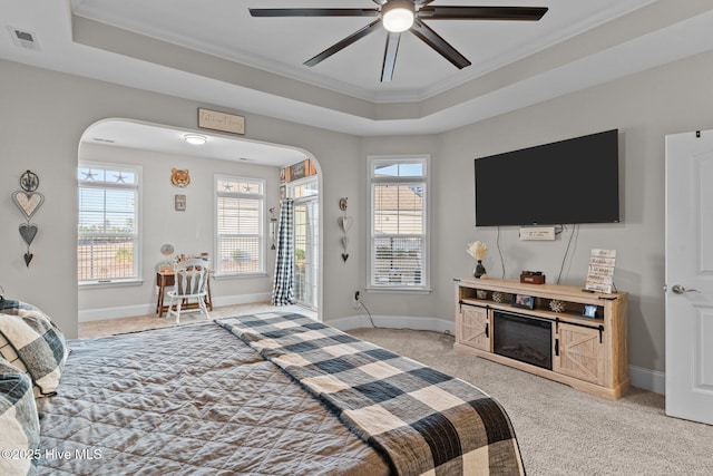 bedroom with arched walkways, visible vents, and a tray ceiling