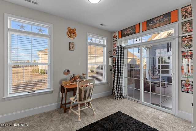 carpeted dining space featuring visible vents and baseboards