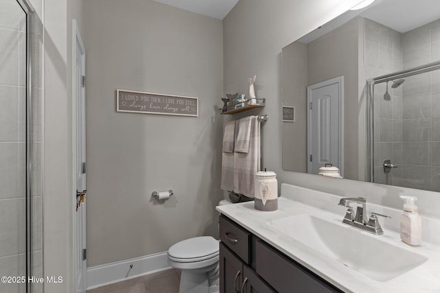 full bathroom featuring tile patterned flooring, a tile shower, vanity, baseboards, and toilet