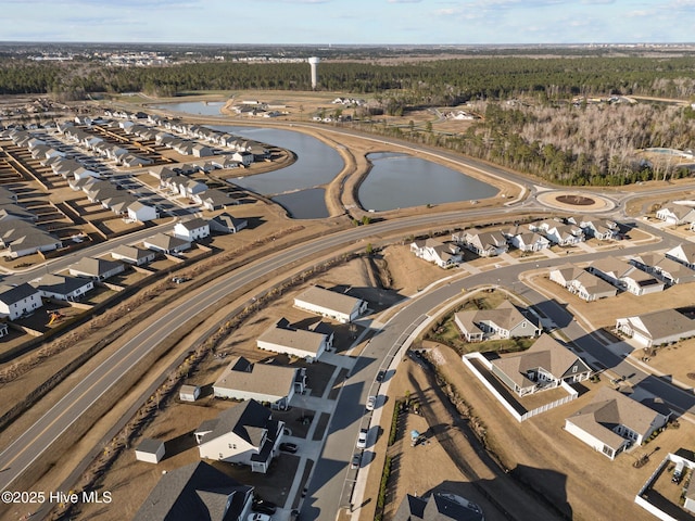 drone / aerial view with a forest view and a water view