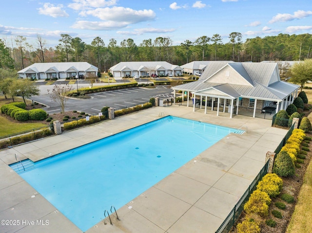 pool featuring a patio area, fence, and a residential view