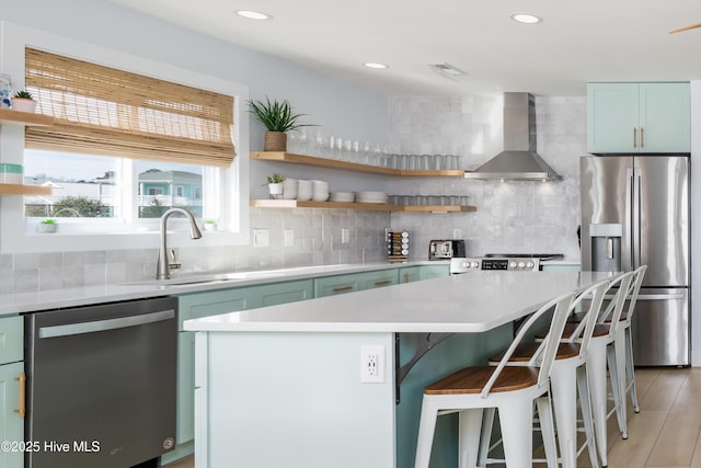 kitchen with appliances with stainless steel finishes, backsplash, wall chimney exhaust hood, and open shelves