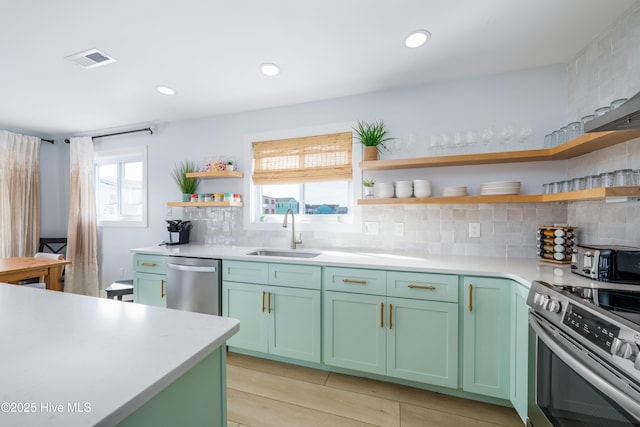 kitchen featuring visible vents, green cabinets, stainless steel appliances, open shelves, and a sink