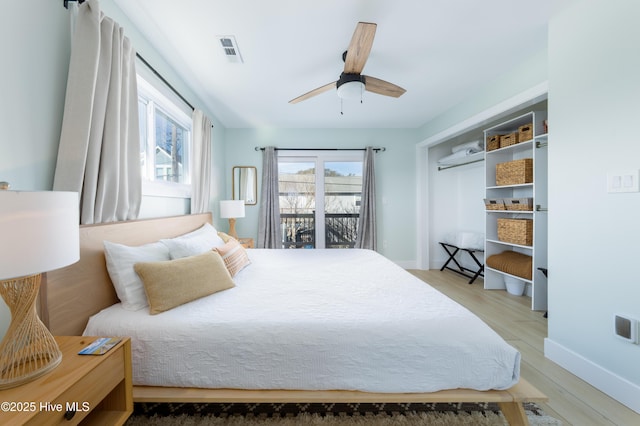 bedroom featuring access to exterior, light wood finished floors, visible vents, and baseboards