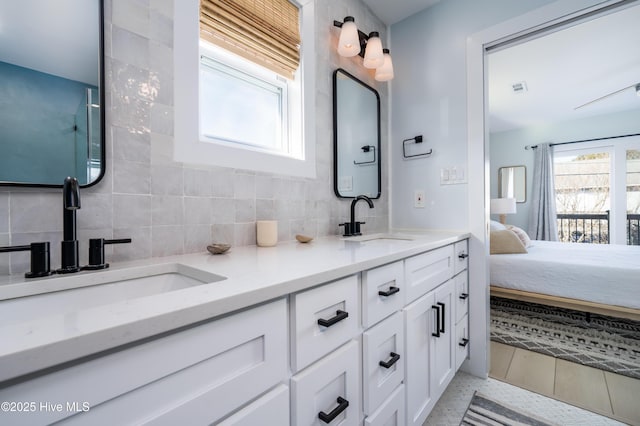 full bath with tasteful backsplash, connected bathroom, a sink, and double vanity