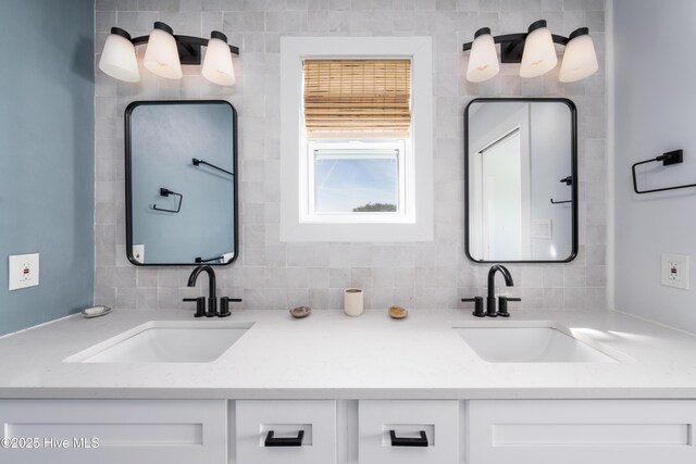 bathroom featuring double vanity, a sink, and decorative backsplash