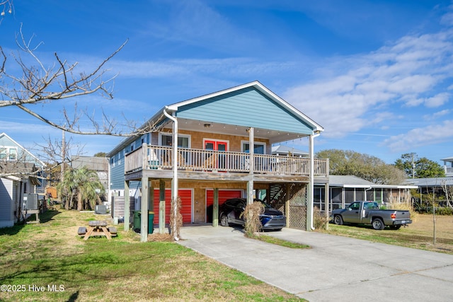 coastal inspired home featuring a carport, concrete driveway, and a front yard