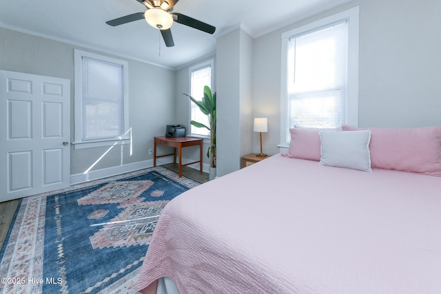 bedroom featuring ornamental molding, a ceiling fan, baseboards, and wood finished floors