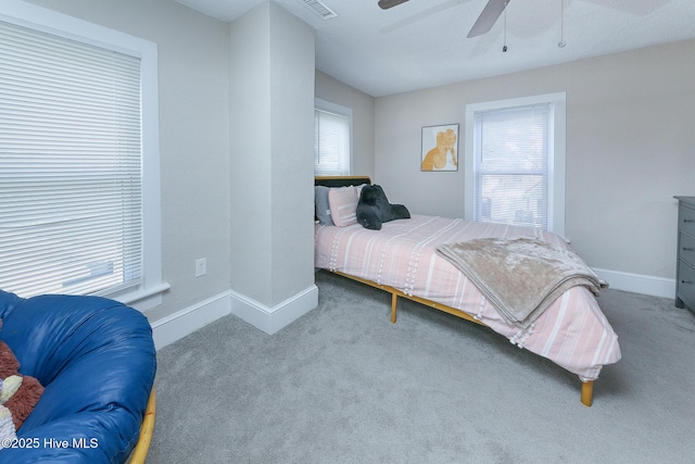 carpeted bedroom with ceiling fan and baseboards