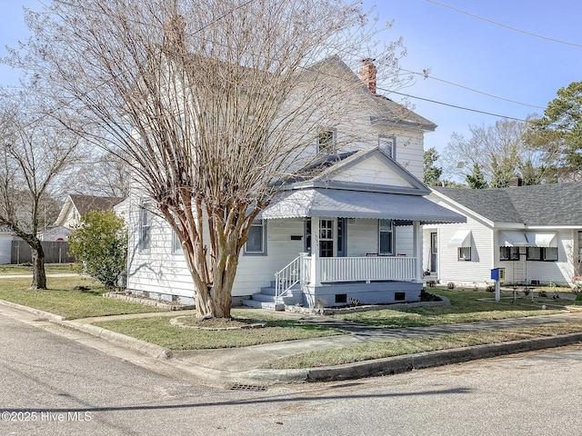 view of front of property with covered porch, crawl space, and a front yard