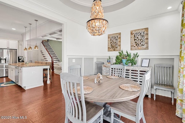 dining space with a decorative wall, crown molding, dark wood-type flooring, stairs, and an inviting chandelier