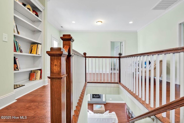 hall with ornamental molding, wood finished floors, visible vents, and recessed lighting