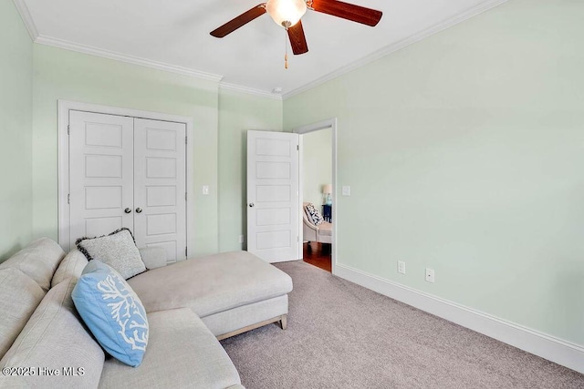 sitting room featuring a ceiling fan, carpet, baseboards, and crown molding