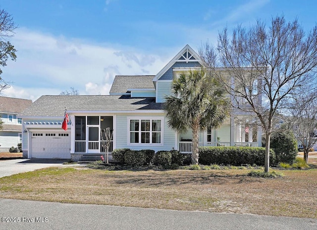 view of front facade with a sunroom, driveway, and an attached garage