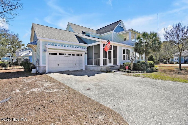 view of front facade with an attached garage, a sunroom, and driveway