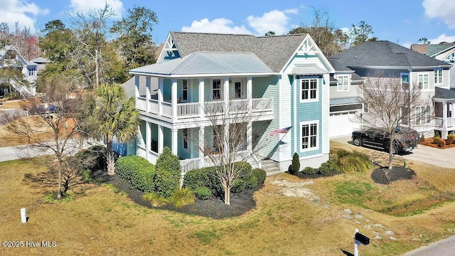 view of front of house featuring driveway, a garage, a balcony, metal roof, and covered porch