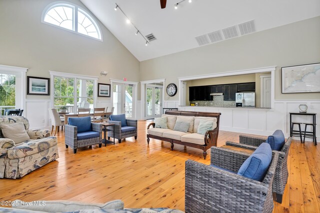 living area with light wood-style floors, french doors, visible vents, and track lighting