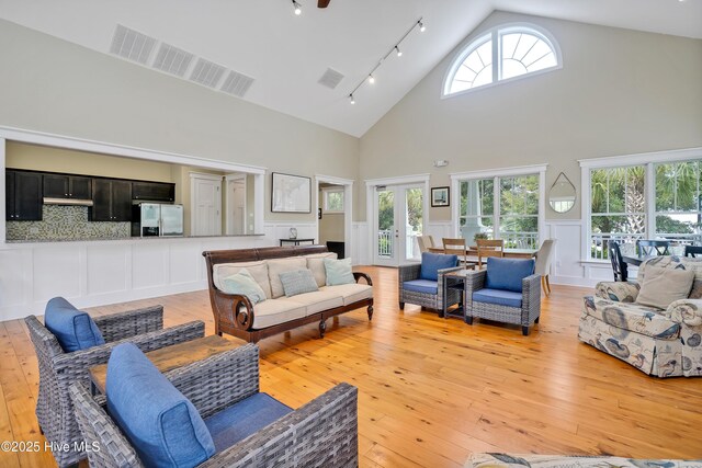 living room with french doors, visible vents, and a decorative wall