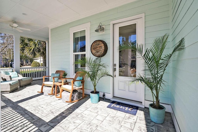 entrance to property featuring covered porch and ceiling fan