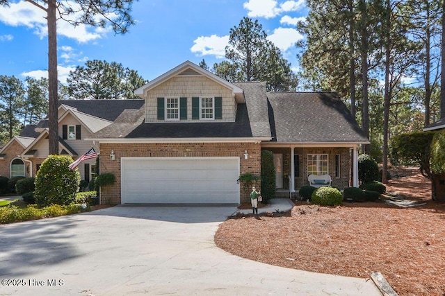 view of front of home with a garage, covered porch, brick siding, and driveway