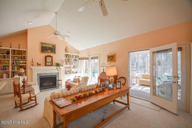 living area featuring a high end fireplace, plenty of natural light, and light colored carpet