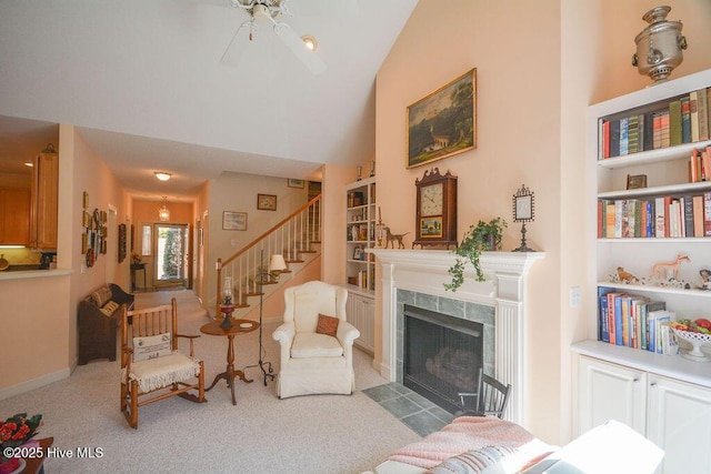 living room featuring high vaulted ceiling, built in features, a high end fireplace, stairway, and carpet