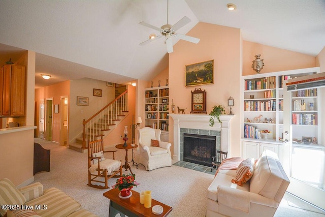 living area featuring high vaulted ceiling, carpet flooring, a fireplace, ceiling fan, and stairs