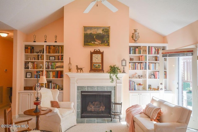 living area featuring vaulted ceiling, built in shelves, a high end fireplace, and ceiling fan