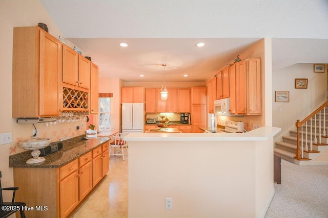 kitchen featuring white appliances, a peninsula, recessed lighting, pendant lighting, and light carpet