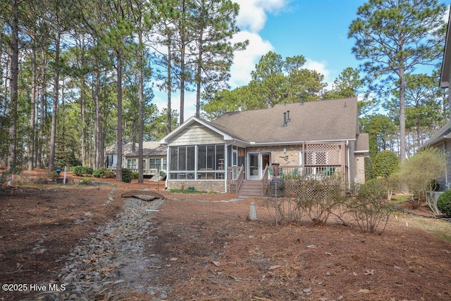 rear view of property featuring a sunroom and a wooden deck